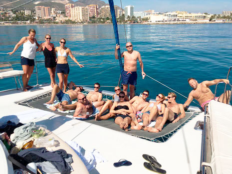 Grupo de amigos tomando el sol en un catamarán